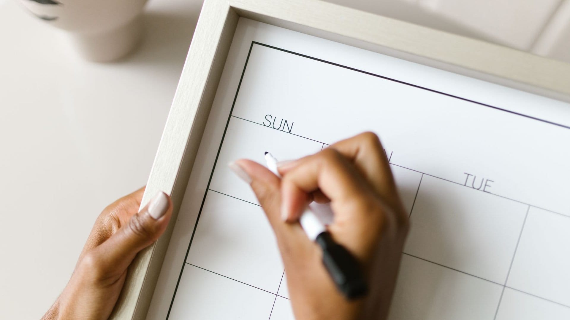 Wochenkalender mit Stift in der Hand – Symbolbild für die richtige Anwendungshäufigkeit eines Klysmas